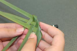a student's hands weaving flax