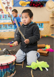 Student playing with drum.