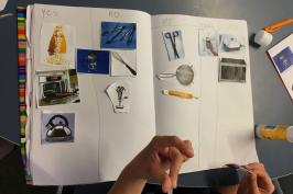 student sticking kitchen items in workbook as technological systems