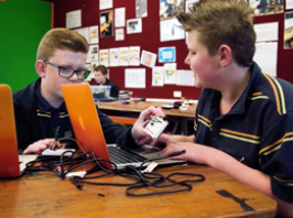 Two students working together with computers and electronics programming