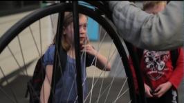 Primary student looks at old bike wheel