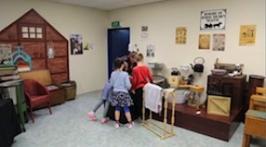 Students and teacher explore an old style room.