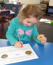 Student writing and holding cookie