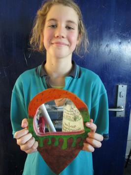 A student holding her finished mirror