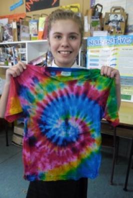 A student holding her tie-dyed t-shirt