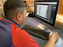 Child at desktop computer designing stick figure shaped animations.