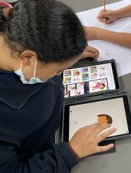 Child creating images on an iPad.