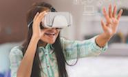 Student wearing virtual reality set and holding out her hand