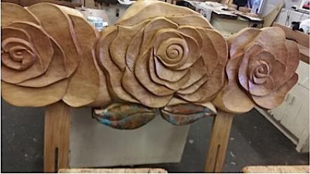 Carved wooden headboard with three flowers and two leaves