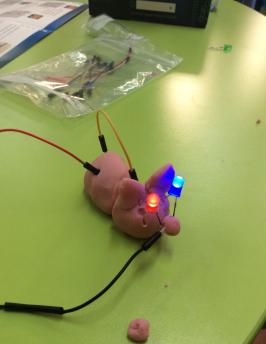 Play dough cat with wired lights attached.