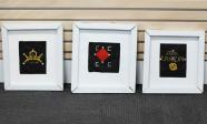 Three framed cross stitched constellation panels with LEDs in them