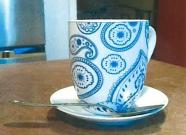 A tea cup, saucer, and teaspoon.