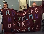Students holding their sunshade deck curtain with letters 